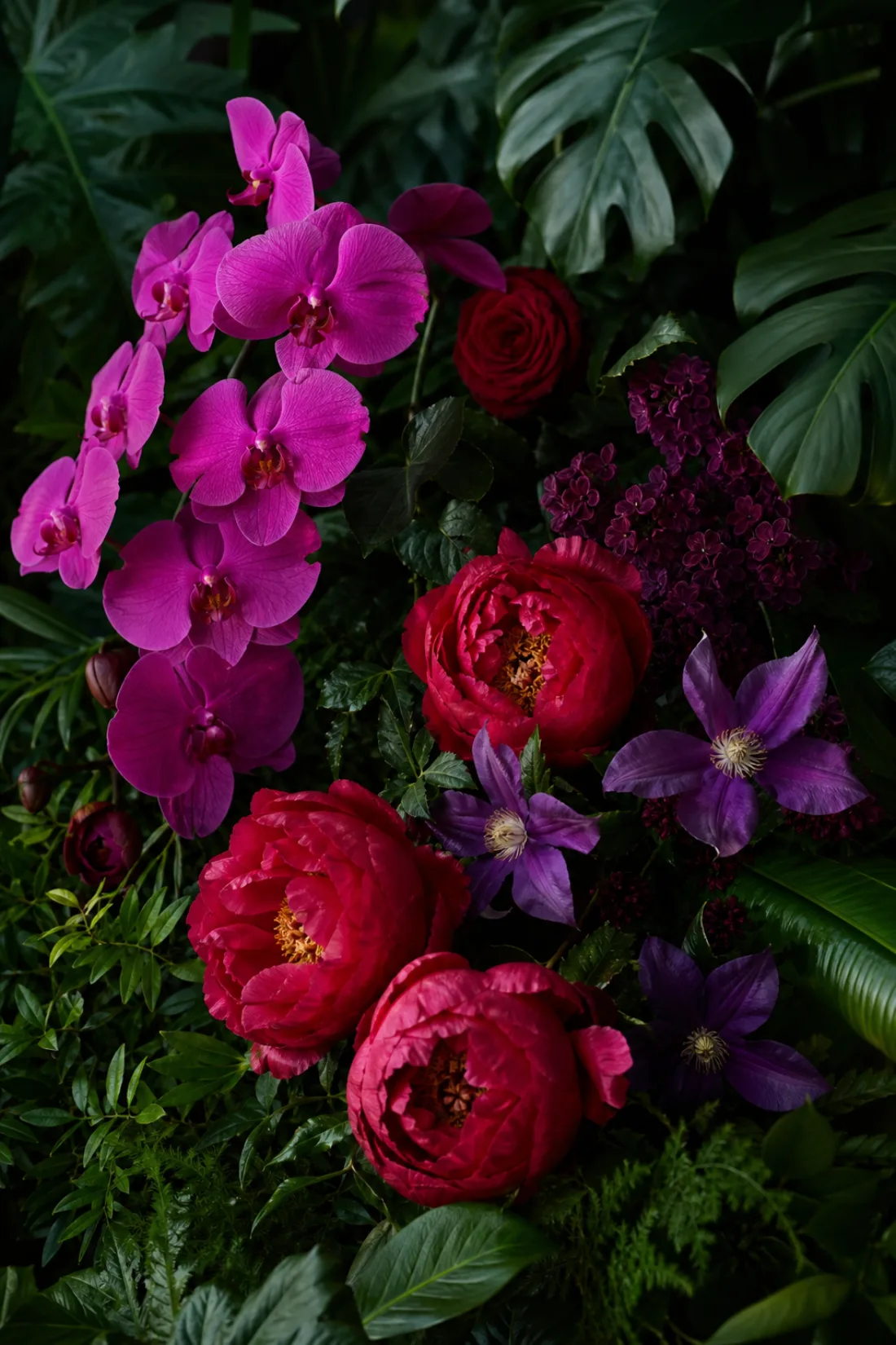 Fuchsia and ruby blooms layered against deep green foliage
